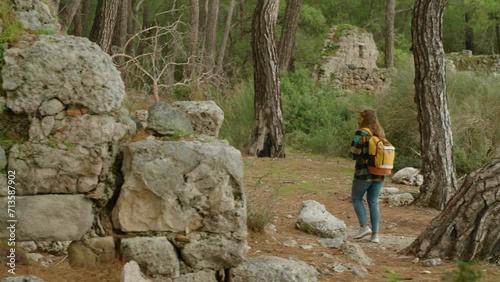 A female tourist who loves history explores the ancient ruins in the forest of the city of Phaselis in ancient Lycia. photo