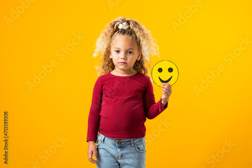 Girl Holding Sad and Happy Emoticons. Children's Emotional Balance.