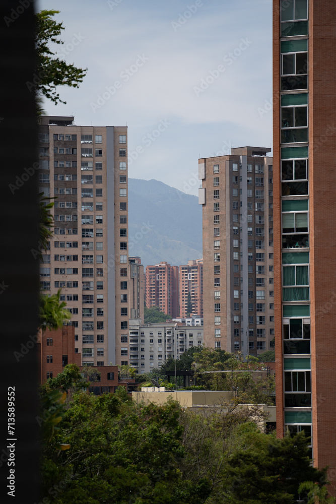 zoom in capture of a city landscape with buildings and nature all around and mountian in background