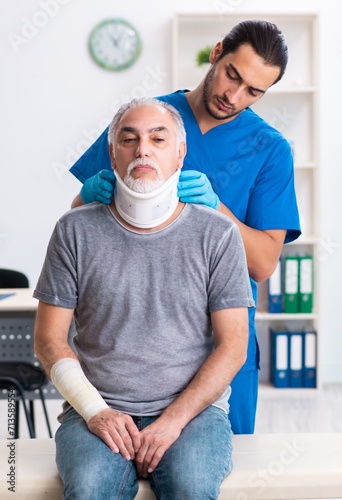 Young male doctor and old patient in first aid concept