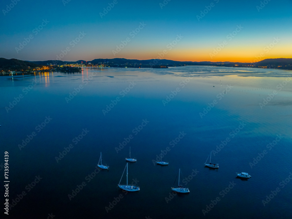 Fototapeta premium Aerial sunrise over the calm water with boats
