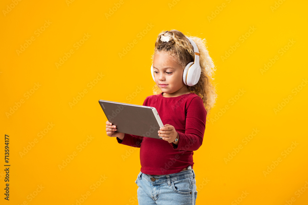 Captivating Portrait of a Joyful Kid Boy with Headphones and Tablet Immersed in Video Game Adventure. Leisure and gadget addiction concept Captivating Portrait of a Joyful Kid Boy with Headphones and Tablet Immersed in Video Game Adventure. Leisure and gadget addiction concept