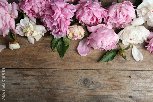 Beautiful peonies on wooden table, flat lay. Space for text © New Africa