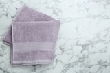 Violet terry towel on white marble table, top view. Space for text