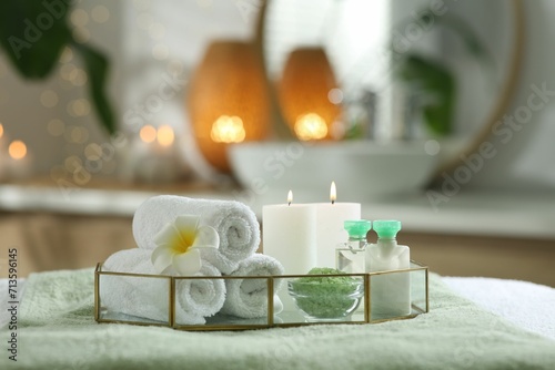 Composition with different spa products and burning candles on table indoors