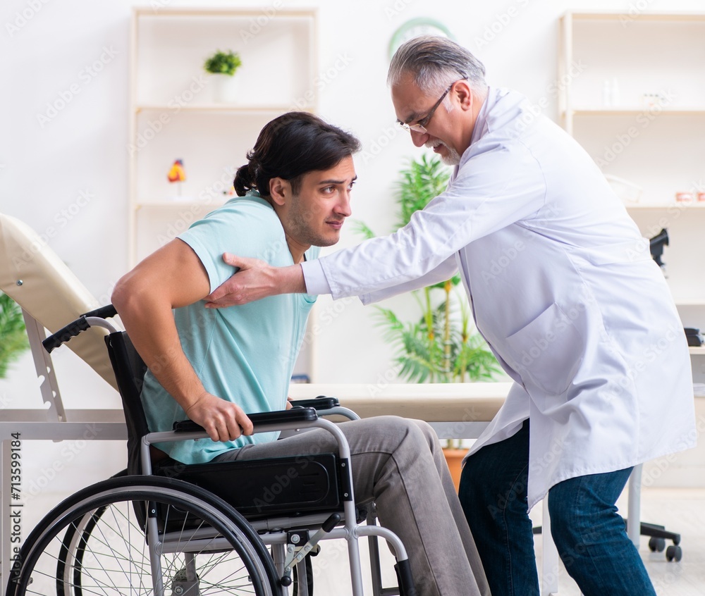 Male patient in wheel-chair visiting old doctor Male patient in wheel-chair visiting old doctor