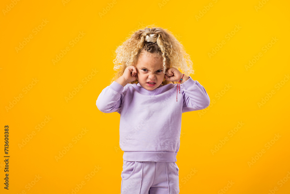 Child girl covering her ears and tightly closed eyes. Unwilling to listen, to hear something. Negative emotions concept Child girl covering her ears and tightly closed eyes. Unwilling to listen, to hear something. Negative emotions concept