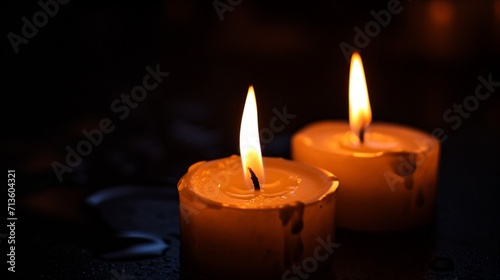 Lighting a candle from another candle in the black background. A practice done during Christian baptisms. photography