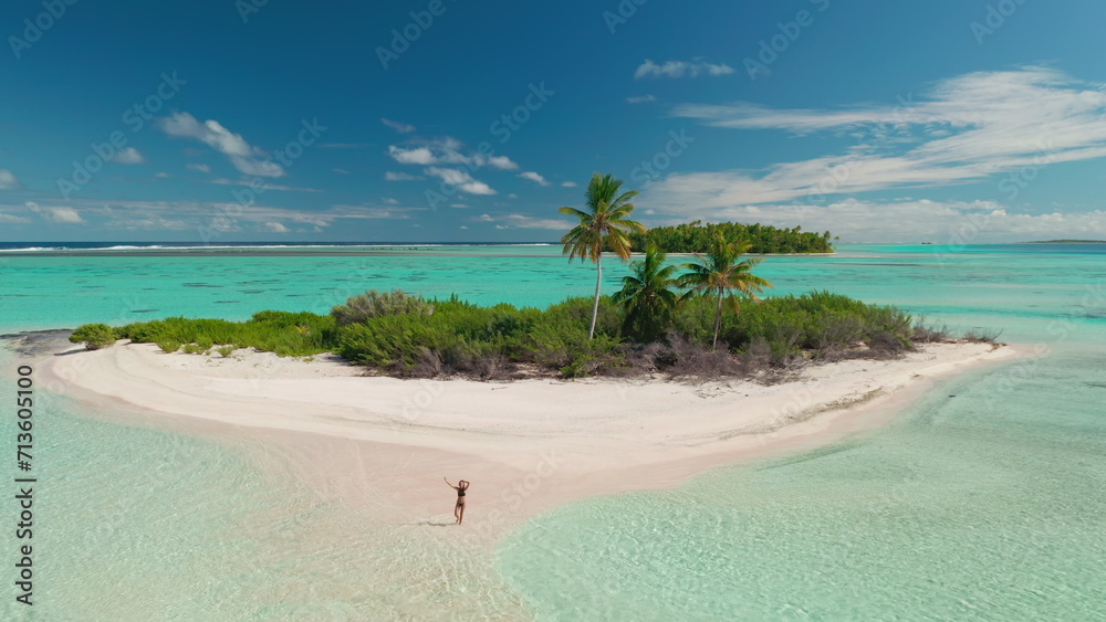 Woman in bikini waving hands relax on tropical island beach. Wild untouched nature, coral reef sea landscape, crystal water, palm trees. Travel summer holiday vacation. Aerial drone flight
