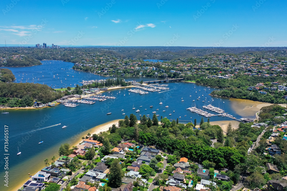 High angle aerial drone view of Spit Bridge, Clontarf Beach and Sandy Bay in the suburb of Clontarf, Sydney, New South Wales, Australia. Northern Beaches area of Sydney and Chatswood in background