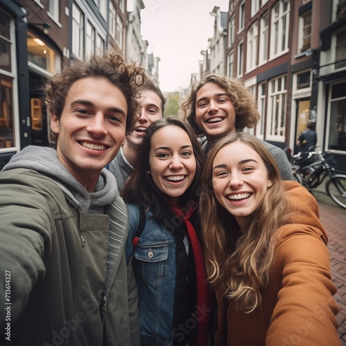 Happy stylish group of young people takes selfie photo in Amsterdam, Netherlands. Student travels abroad and takes pictures for his blog.