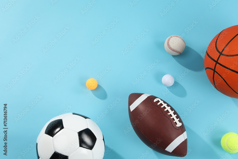 Many different sports balls on light blue background, flat lay. Space for text Many different sports balls on light blue background, flat lay. Space for text