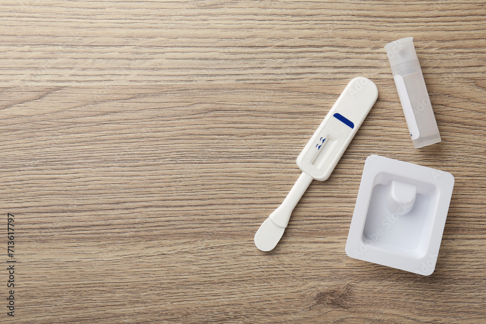 Disposable express test kit on wooden table, flat lay. Space for text Disposable express test kit on wooden table, flat lay. Space for text