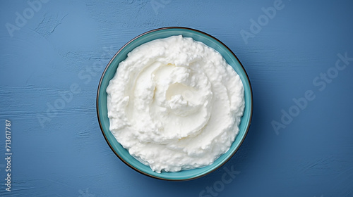 Cottage cheese in a bowl on a blue background, top view	