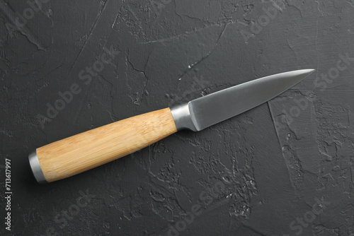 One sharp knife on dark textured table, top view