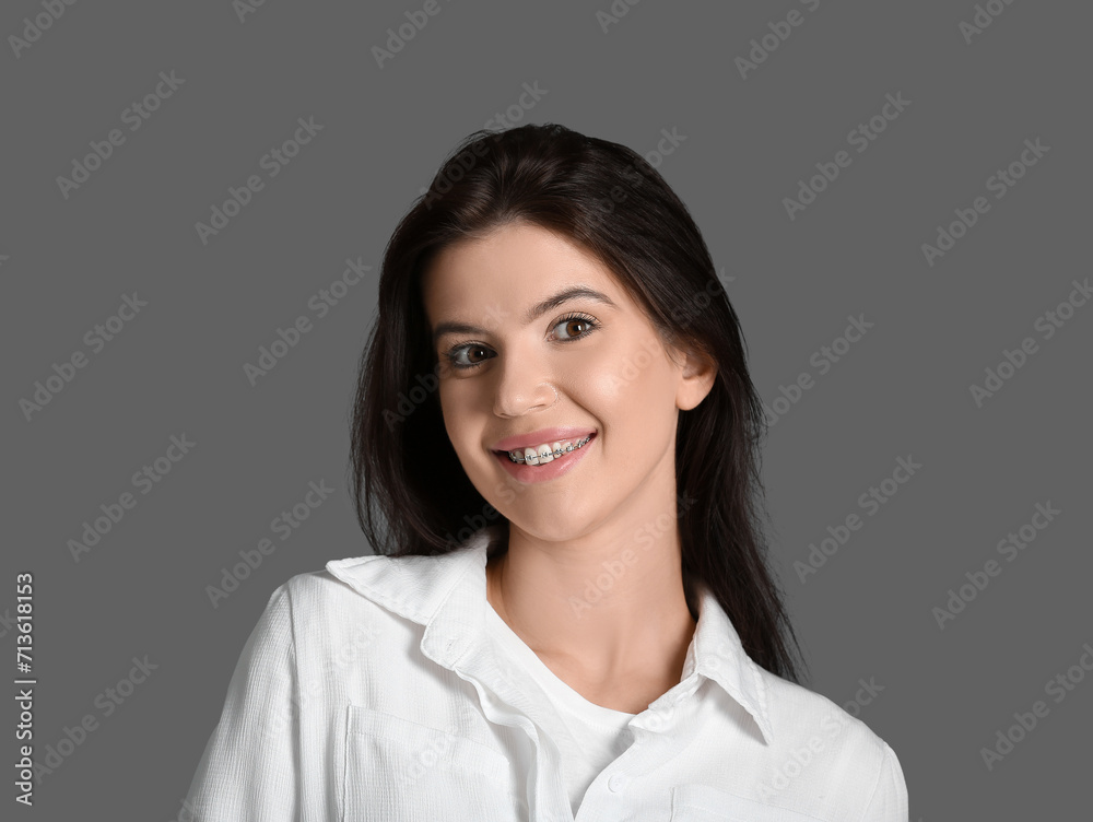 Young woman with dental braces on grey background, closeup Young woman with dental braces on grey background, closeup