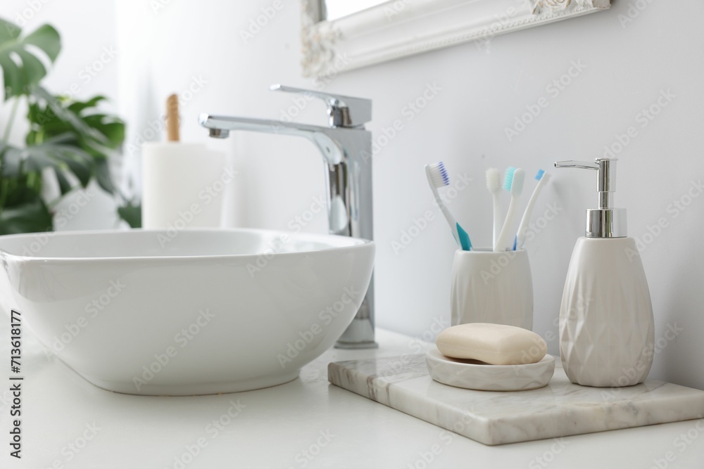 Different bath accessories and personal care products near sink on bathroom vanity Different bath accessories and personal care products near sink on bathroom vanity
