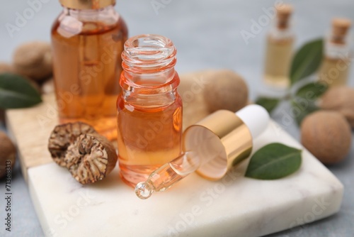 Nutmeg essential oil and nuts on table