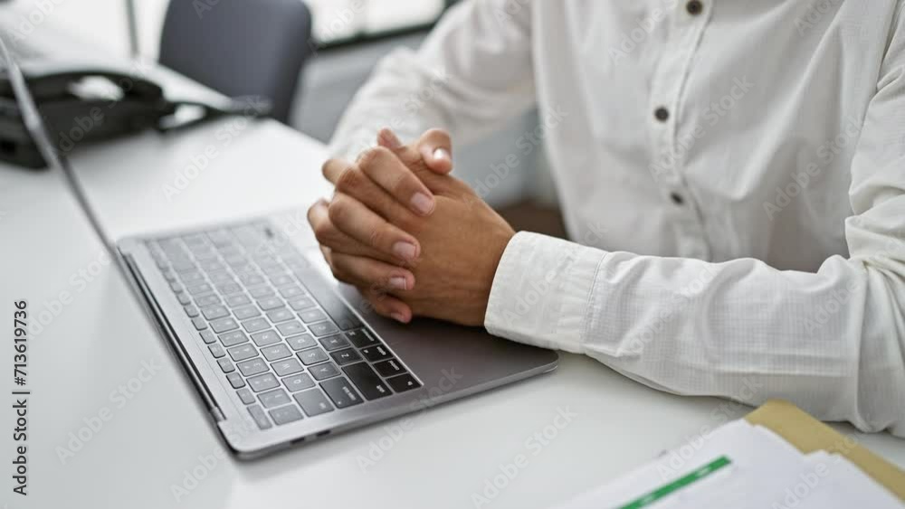 Hispanic man juggling work, hands flying over laptop, typing away in the heart of business, office chaos; success echoes in the room Hispanic man juggling work, hands flying over laptop, typing away in the heart of business, office chaos; success echoes in the room
