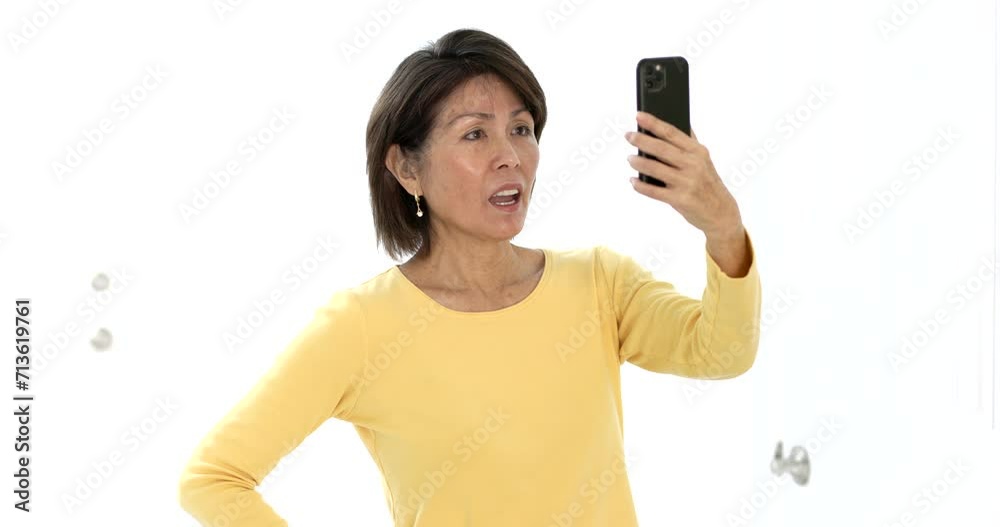 Happy attractive woman smiling enjoying looking at mobile phone laughing talking using face time video chat studio lighting. Happy attractive woman smiling enjoying looking at mobile phone laughing talking using face time video chat studio lighting.