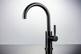 Close-up of modern black matte kitchen faucet, black acrylic stone countertop against the background of white wall with spot lighting. Copy space.