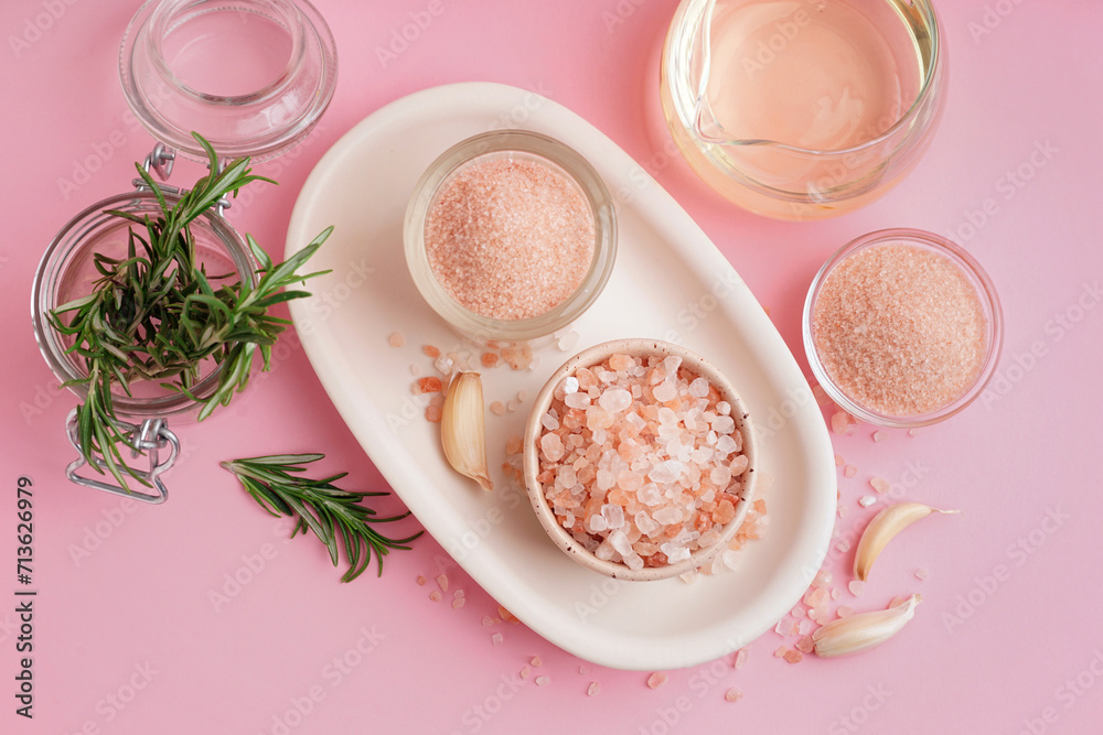 Bowls with Himalayan pink salt and garlic on pink background Bowls with Himalayan pink salt and garlic on pink background