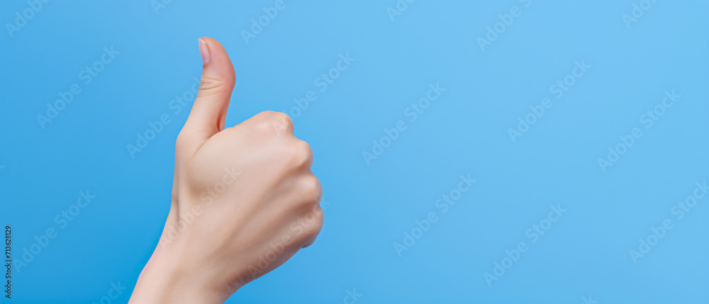 A thumbs-up from a woman hand, expressing approval or giving a like. A thumbs-up from a woman hand, expressing approval or giving a like.