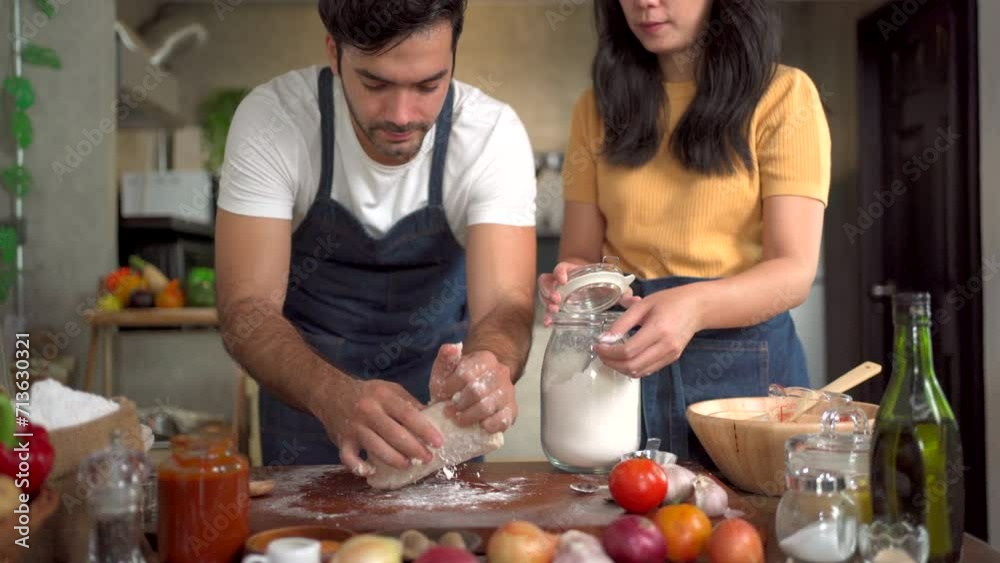 Women and men knead dough together, creating a lively, aromatic atmosphere in the kitchen as they prepare to make pizza. Women and men knead dough together, creating a lively, aromatic atmosphere in the kitchen as they prepare to make pizza.