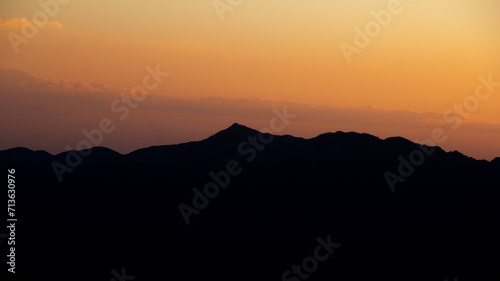 majestic distant mountain ridge silhouette during colorful sunset