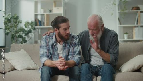 Deep conversation between generations young man and elder on the couch discuss life, experience exchange, heartfelt communication, emotional support, understanding differences mentoring, family values