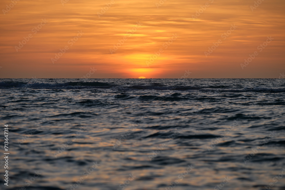Ocean sunset. Big white sun on dramatic bright sky background, soft evening horizont over sea dark water Ocean sunset. Big white sun on dramatic bright sky background, soft evening horizont over sea dark water