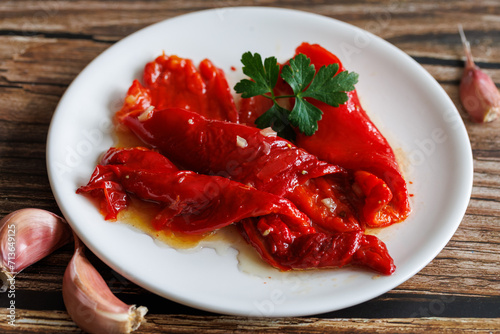 Peeled peppers, salad from grill baked marinated vegetable pepper, grilled fresh, portion on plate, ready to eat meal snack on the table, close up, food background, rustic
