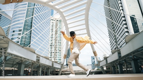 Stylish asian man perform hiphop dancing with low angle camera. Break dancer walking up the stair while listening music from headphone and dancing together at city. Outdoor sport 2024. Sprightly. © Summit Art Creations