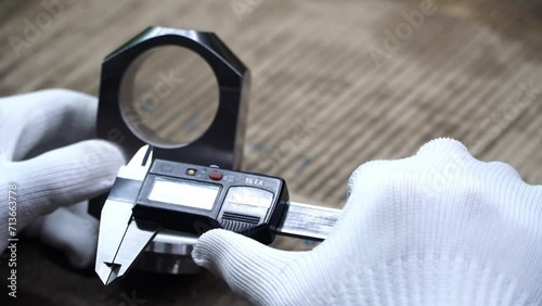 Work at the Heavy Industry Manufacturing Facility concept,technician measures metal parts by hand using a digital vernier caliper in a heavy product.