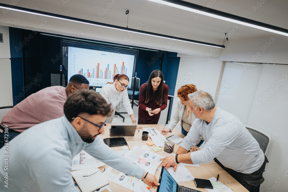 Multi generational business team collaborating, analyzing stats, sharing ideas for profit growth. Multi generational business team collaborating, analyzing stats, sharing ideas for profit growth.