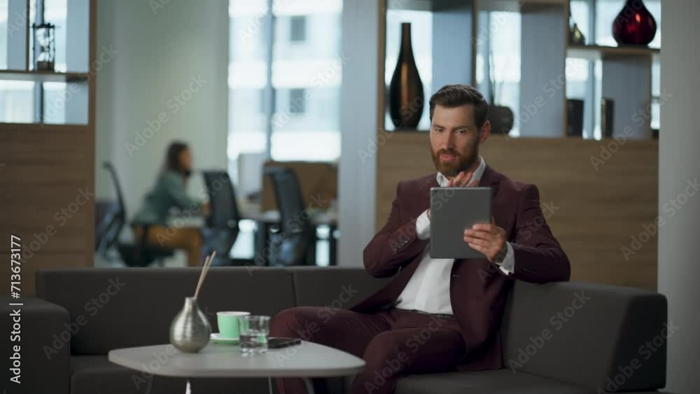 Serious lawyer talking digital discussion at modern hall. Man holding tablet Serious lawyer talking digital discussion at modern hall. Man holding tablet