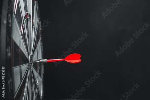 Bullseye is a target of business. Dart is an opportunity and Dartboard is the target and goal. challenge in business marketing business success concept. Dark black background. Cpoy space for text.