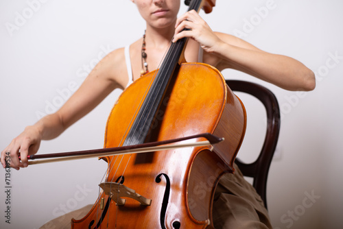 A young woman playing cello on the concert at night.