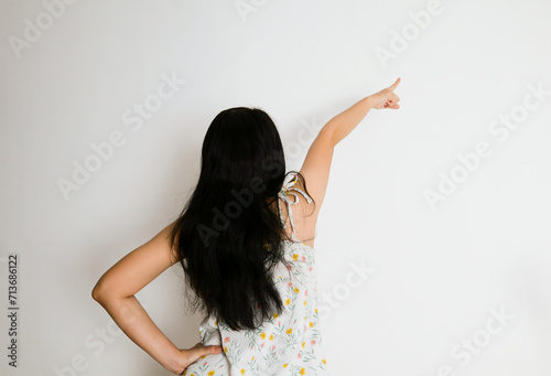 a woman points in a direction from the back view