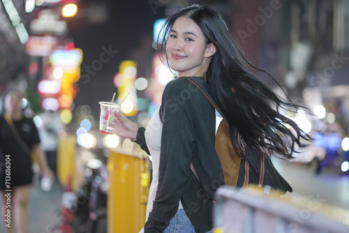 asian woman traveller backpack. Happy young tourist woman on street. Young woman at Bangkok Chinatown street night market. city lifestyle shopping and eating street food concept. travel. vacation.