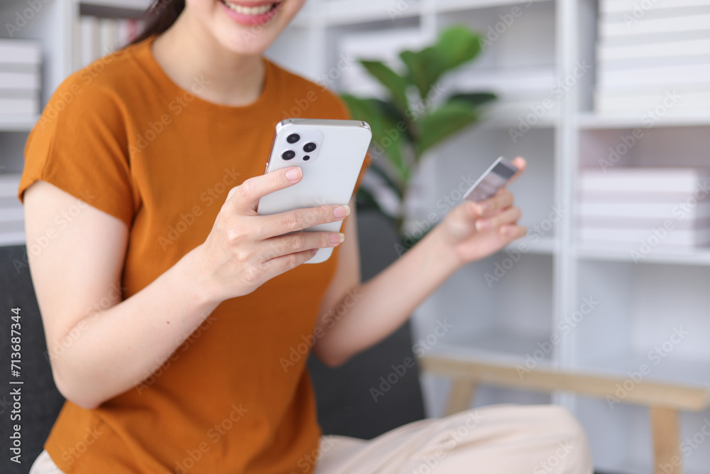 Happy young asian woman using credit card and mobile phone shopping online. Online payment via credit card. Happy young asian woman using credit card and mobile phone shopping online. Online payment via credit card.