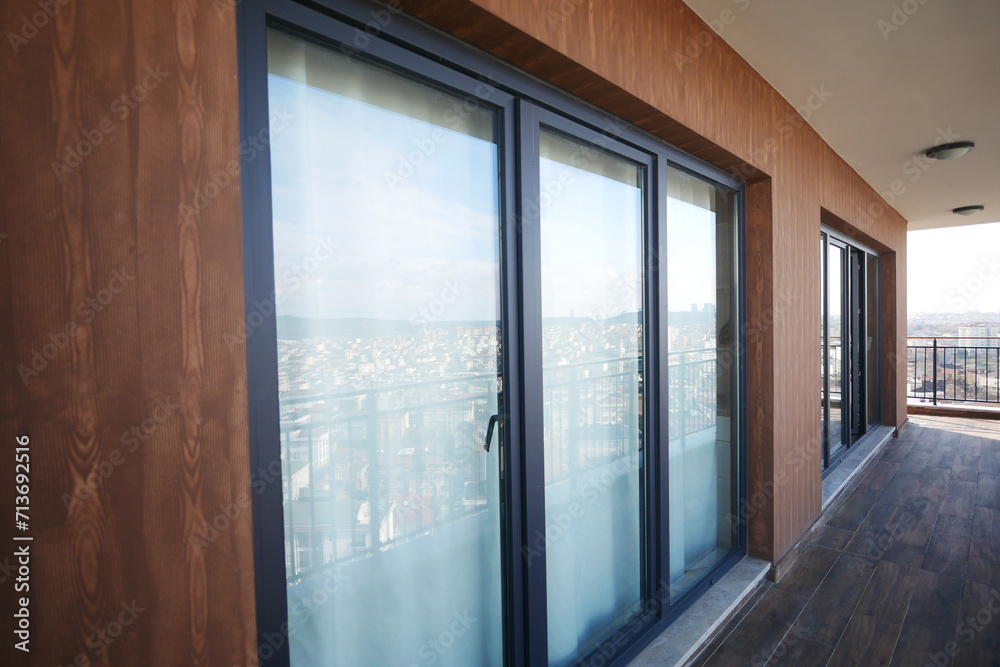 Fototapeta premium Modern front window with thin curtains and house walls from the outside view.