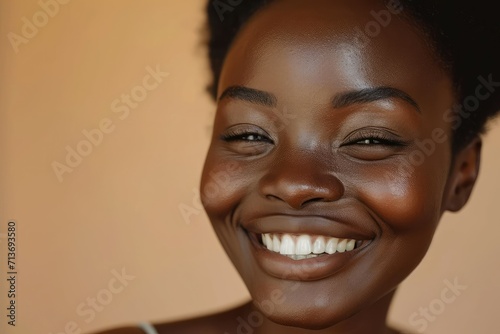 Beaming African girl showcasing skin health, close up, beige backdrop © Lucija
