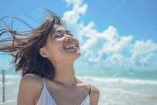 Carefree Asian woman on beach, joyful and relaxed in vacation setting © Lucija