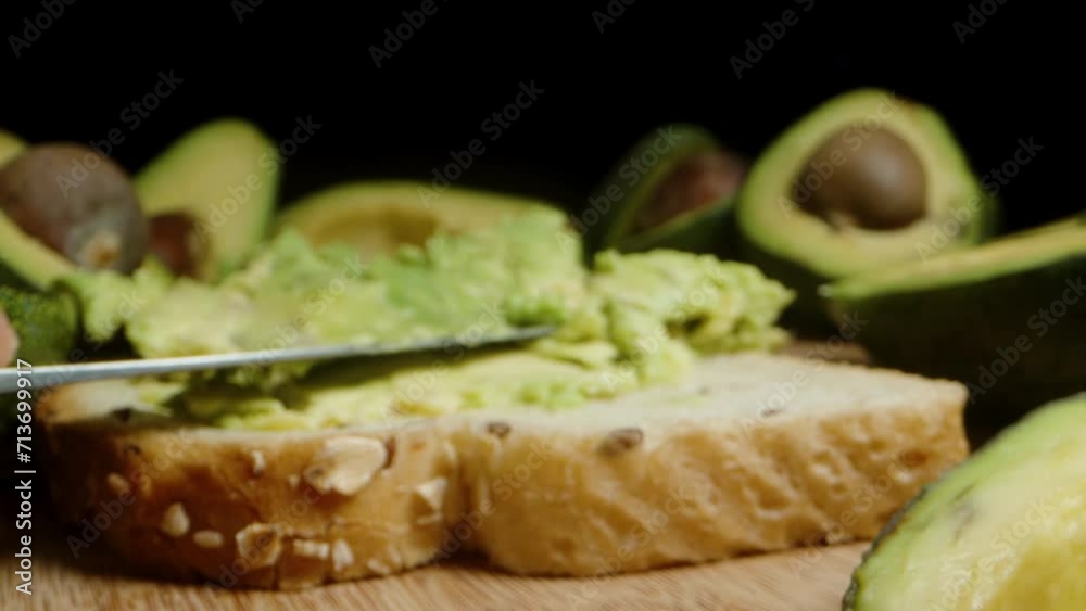 Spread fresh avocado puree on bread for a healthy breakfast. Dolly slider extreme close-up. Spread fresh avocado puree on bread for a healthy breakfast. Dolly slider extreme close-up.