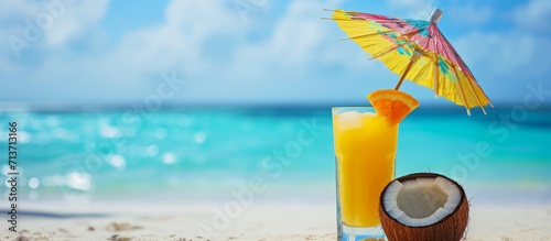 Tropical Orange Cocktail on Pristine Beach with Coconut