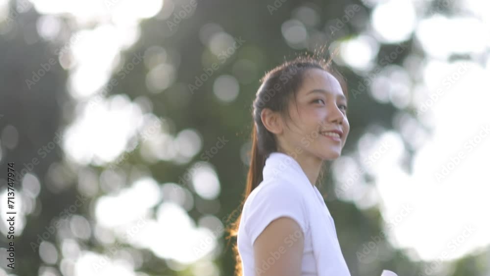 Young beautiful Asian woman is exercising on the sidewalk in the park. Young beautiful Asian woman is exercising on the sidewalk in the park.