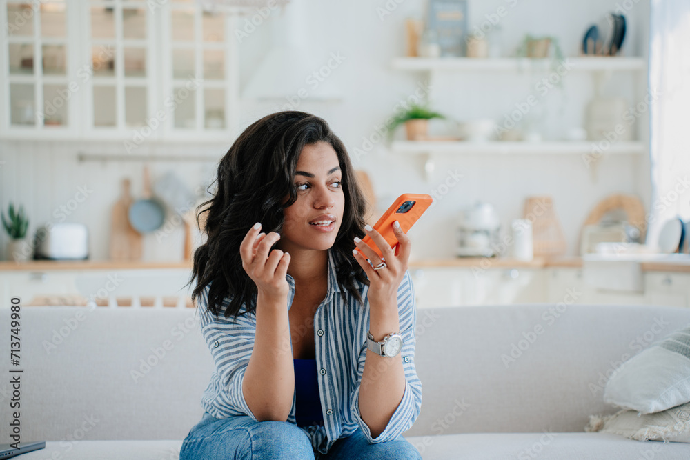 Young woman using smartphone at home, recording audio message. Young woman using smartphone at home, recording audio message.