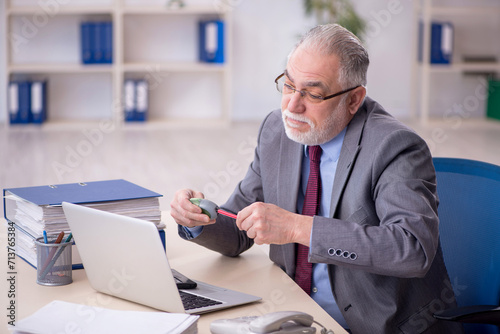 Old male employee working in the office