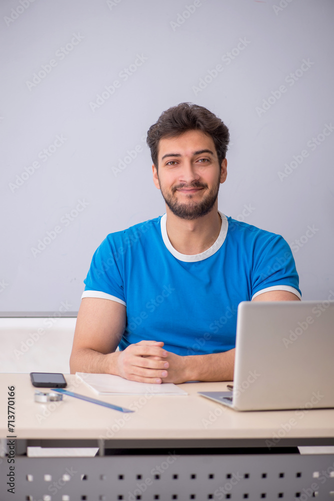Young male student in front of whiteboard Young male student in front of whiteboard